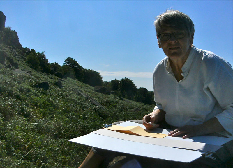 Picture of Annie Sketching outdoors on location near rocks at Stanage in the Peak District National Park.