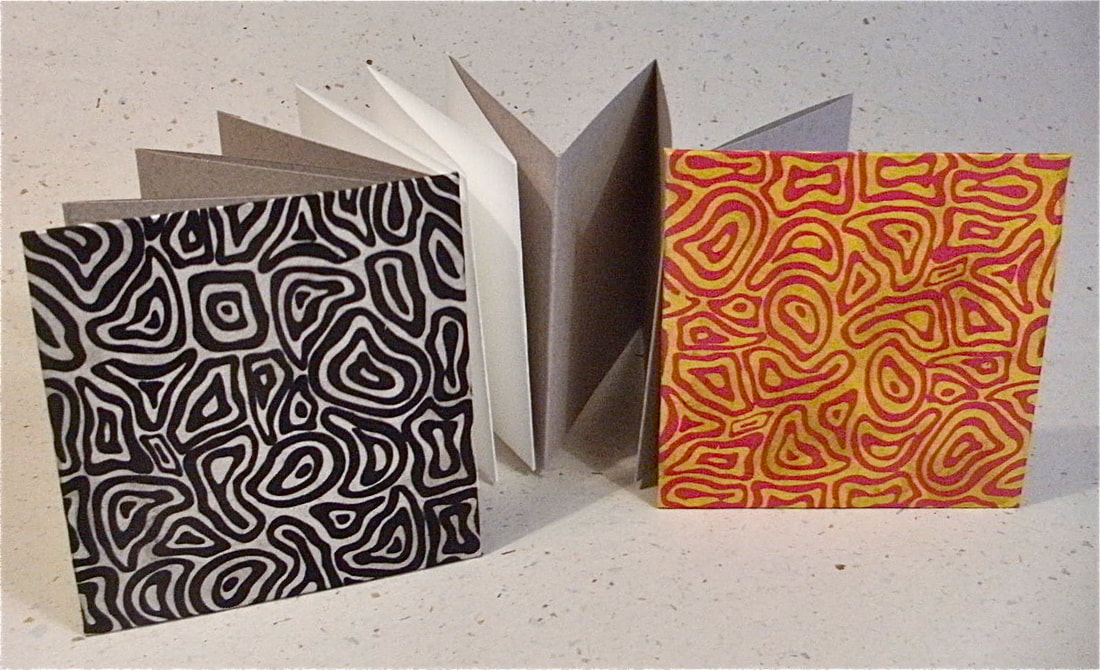 Handmade concertina pocketbook with white and beige pages and psychedelic patterned covers in 2 colourways